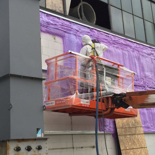 Four Seasons contractor sealing building exterior with spray foam insulation